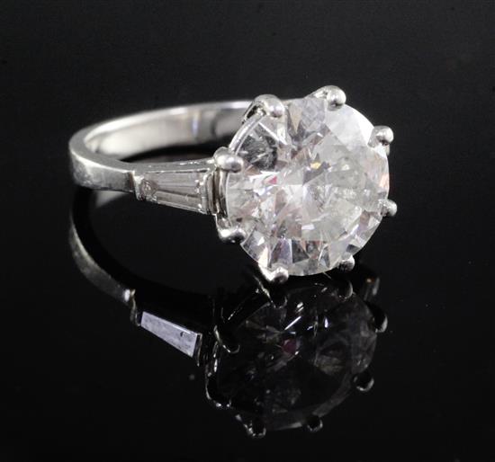 An attractive modern platinum and single stone diamond ring with trapeze cut diamond set shoulders, size K.